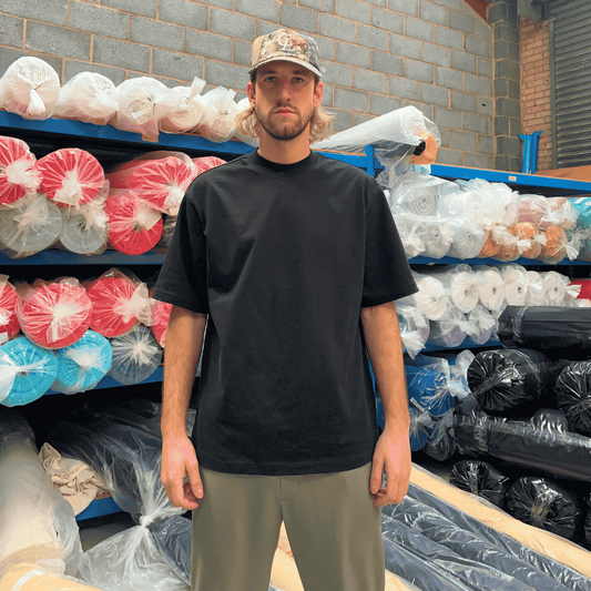 Man wearing a streetwear blank t-shirt in a black colourway using 100% cotton heavy fabric