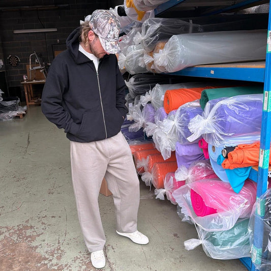 Person standing in a warehouse with shelves filled with colorful plastic bags.