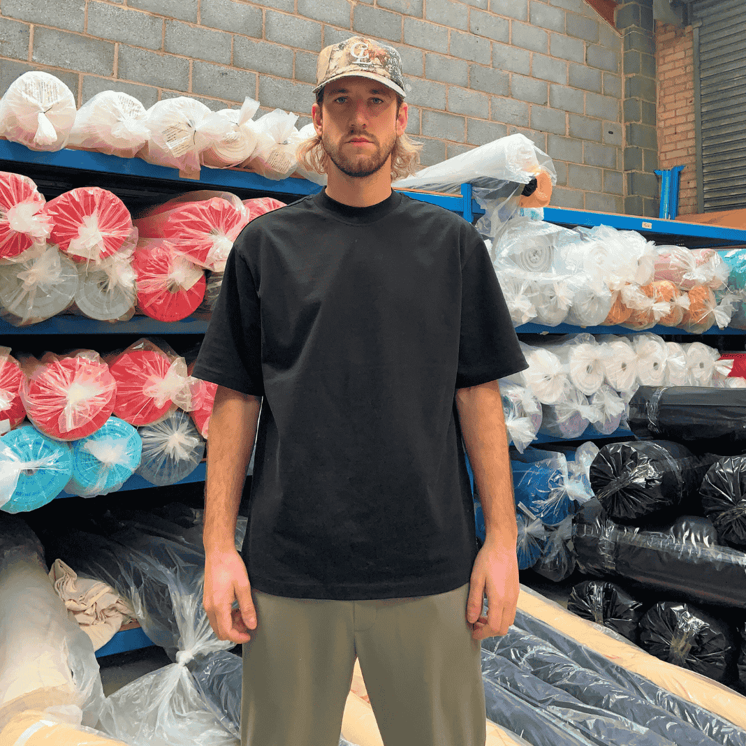 Man wearing a streetwear blank t-shirt in a black colourway using 100% cotton heavy fabric