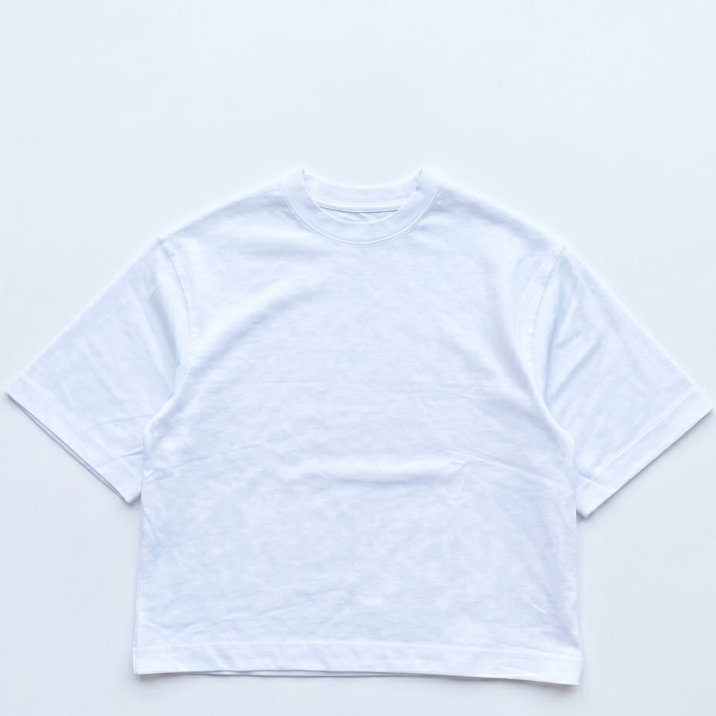White crop top on a light gray background