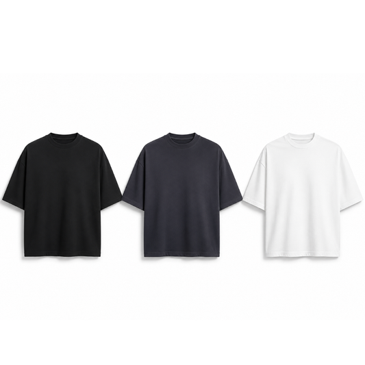Three plain t-shirts in black, gray, and white on a white background